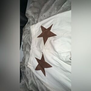 White jeans with brown stars on the back pocket